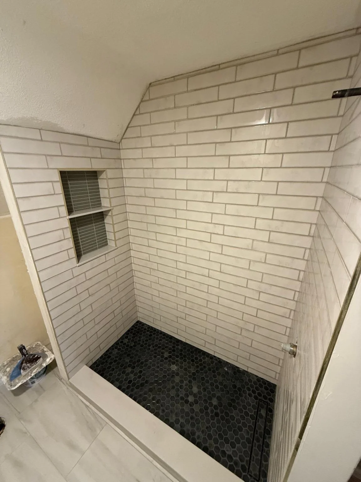 White subway tile and dark mosaic floor