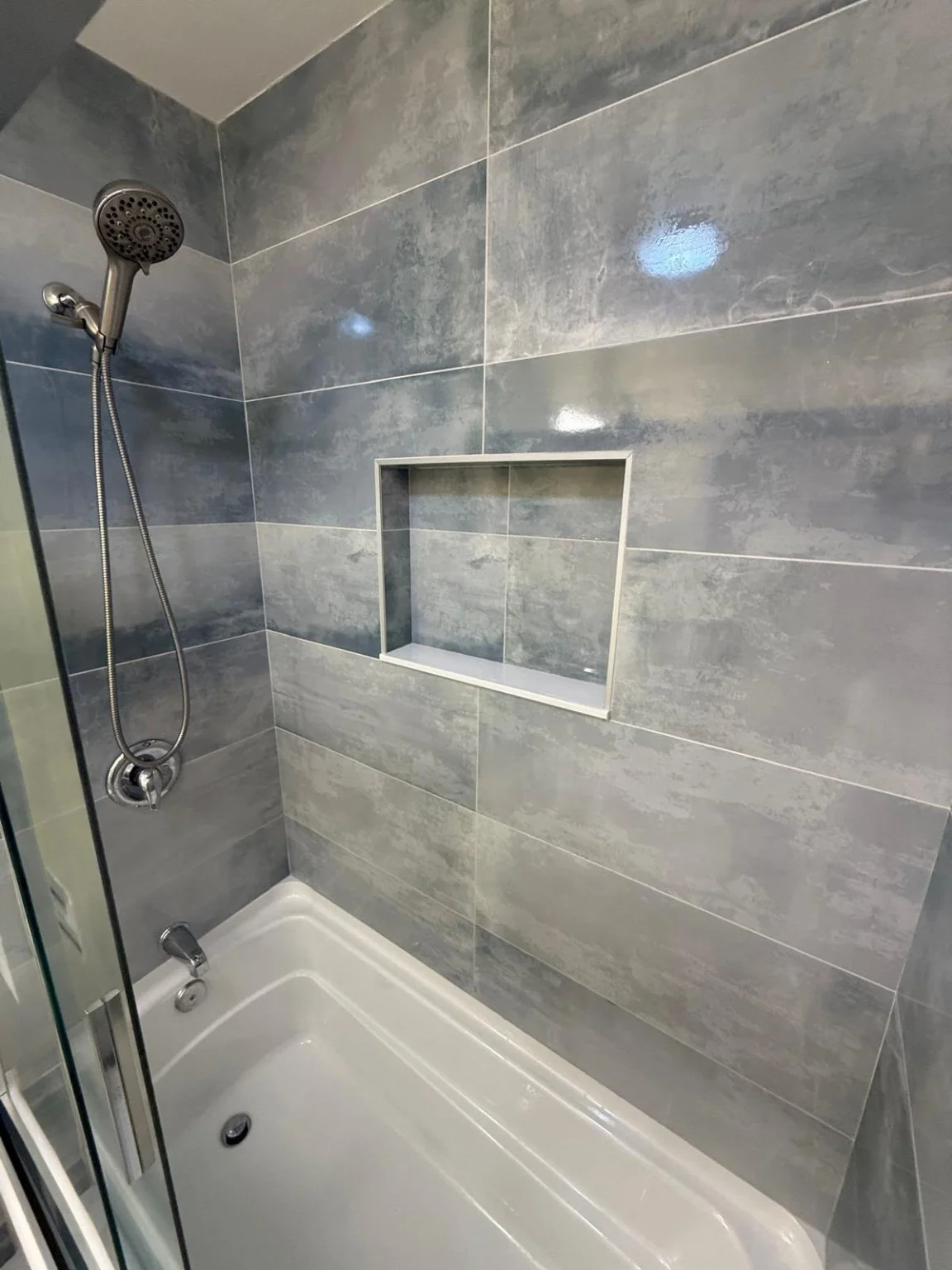 Gray tile and horizontal shower niche