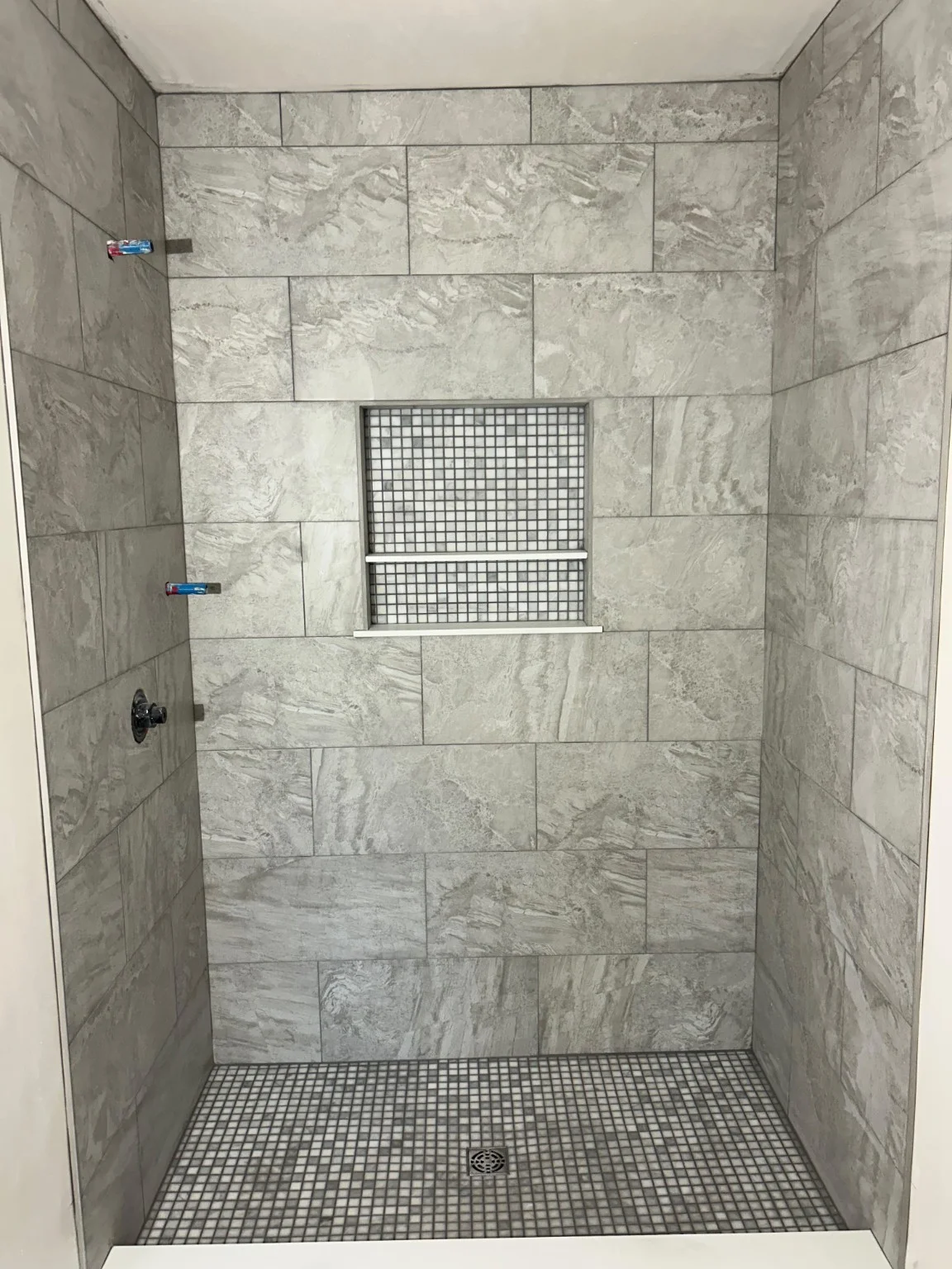 Marble-look shower tile and mosaic niche